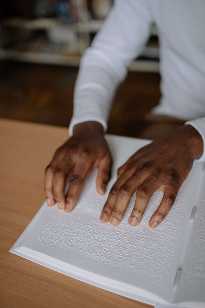 Pessoa a ler livro em Braille